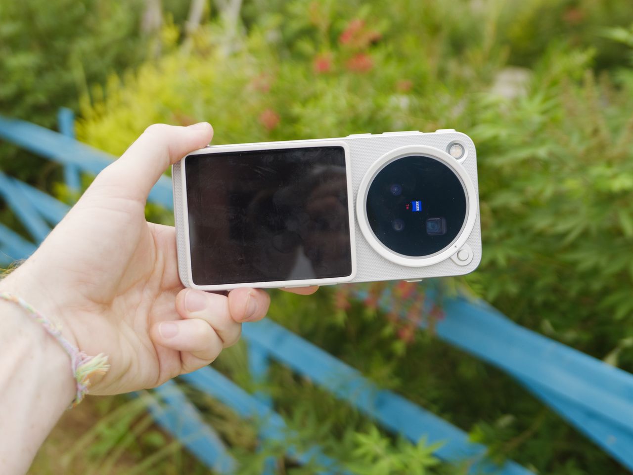 The Vivo X500 Pro Max phone in user's hand, in its dedicated case for magnetic accessories, with Vivo's selfie screen attached