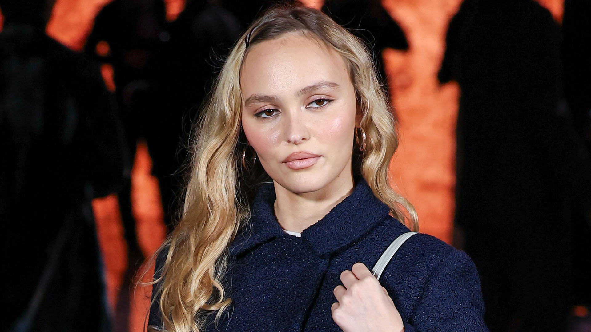 Lily-Rose Depp wearing a navy suit and pattern tights