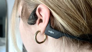 Shokz OpenRun Pro bone conduction headphones wrapped around a woman's ears