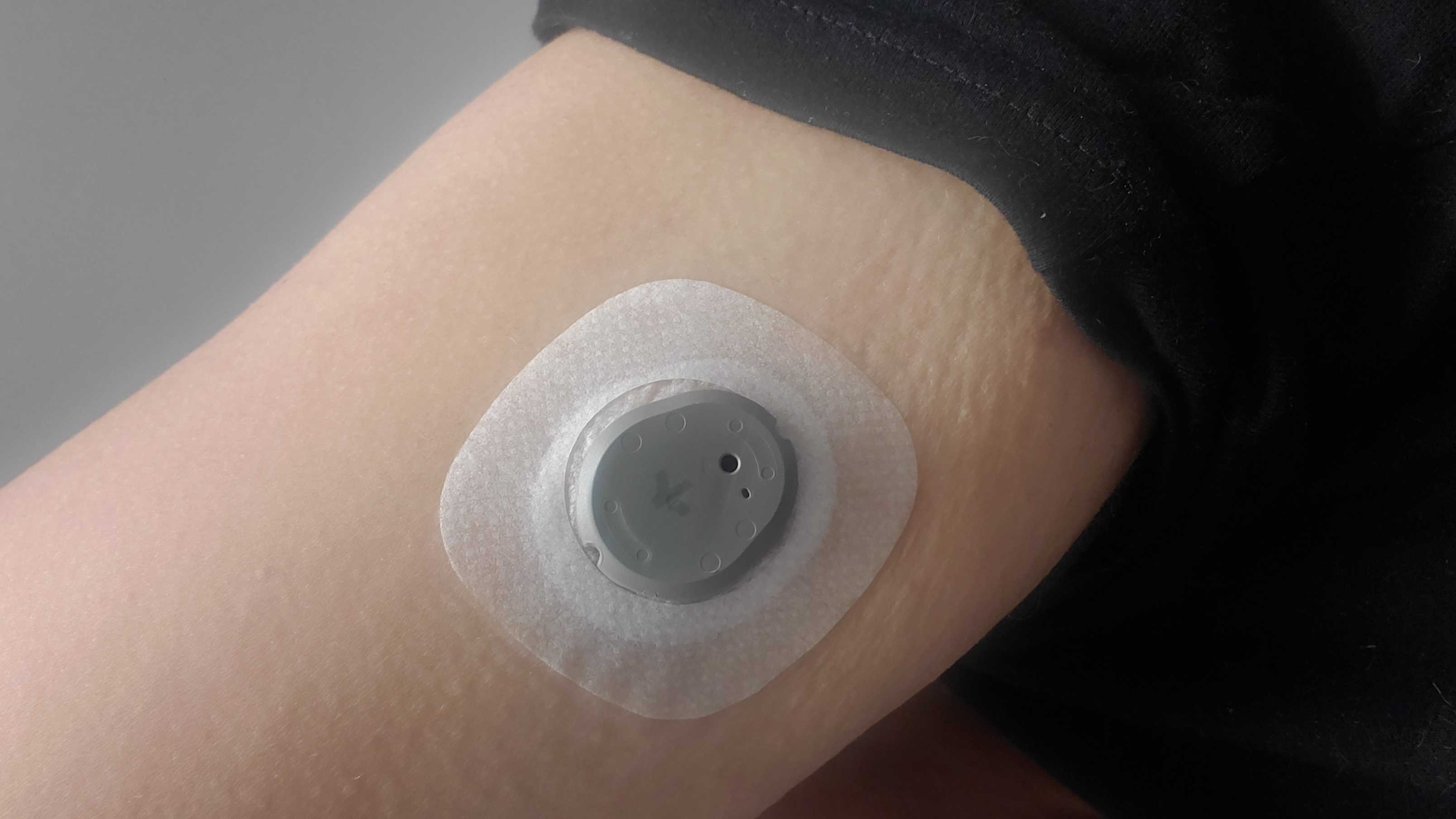 The biosensor attached to an arm, as well as the applicator