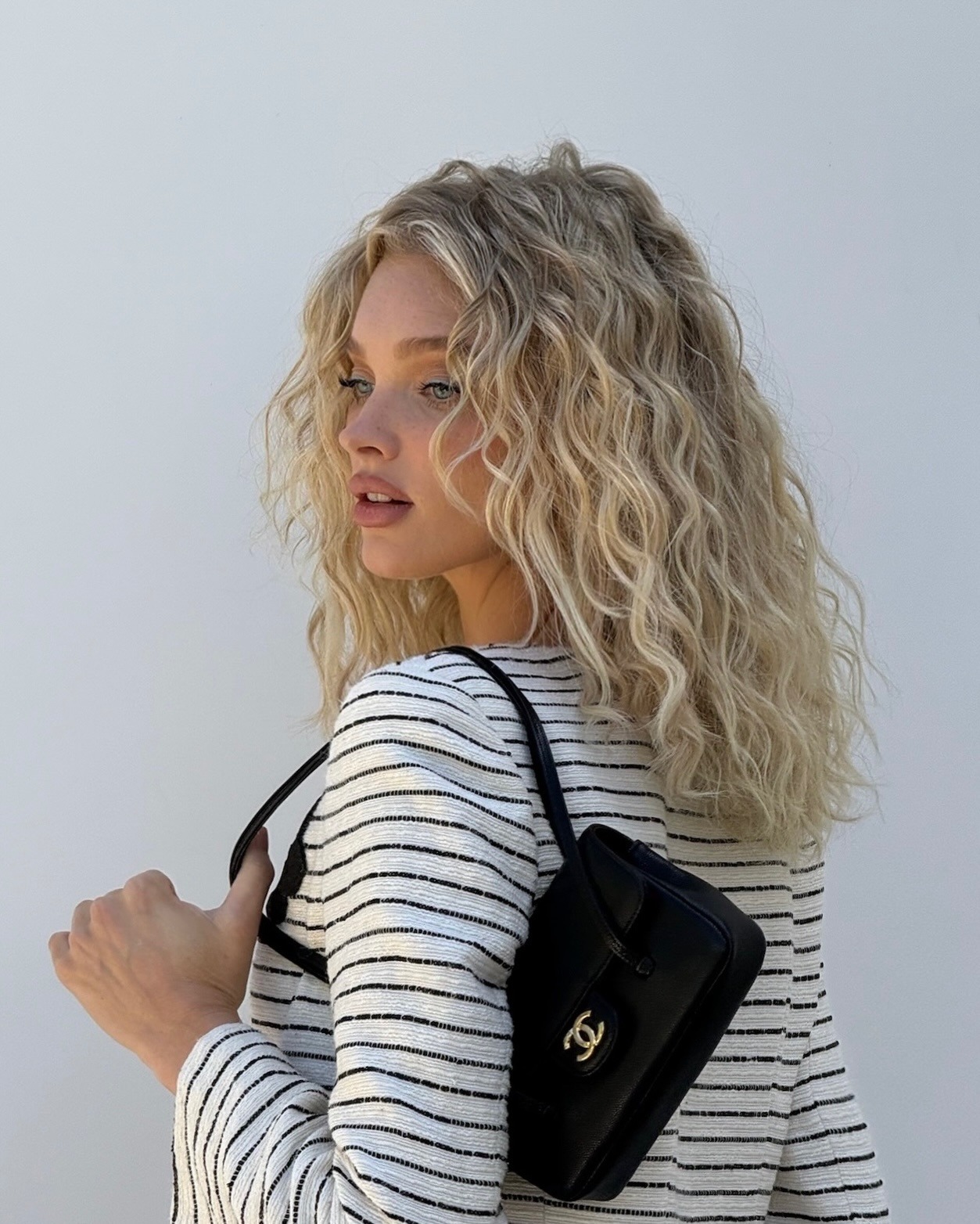 Elsa Hosk wearing a stripe t-shirt with a curly lob hairstyle