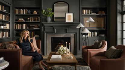 Shea McGee sitting in a dark, moody, cozy living room