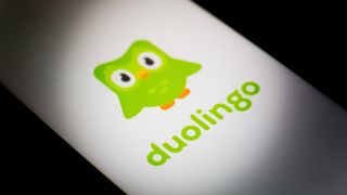 The Duolingo logo (a green owl above green text reading "duolingo") on a white phone screen against a black background.