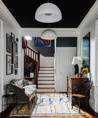 Hallway with black paint on ceiling and Moroccan rug