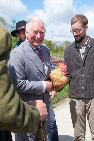 King Charles holding a chicken