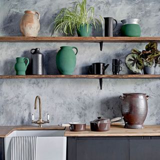 kitchen with walled grey tiles wooden countertop with rectangle wash basin with clay pots