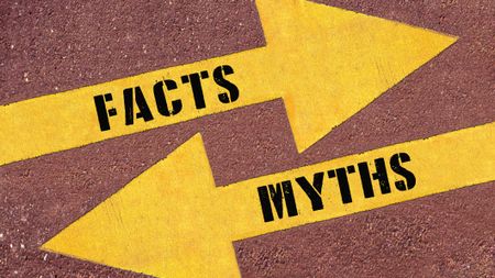 FACTS or MYTHS , words on Two arrows. Two Yellow Arrows Painted on Asphalt showing different directions