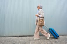 Woman dragging a suitcase toward airport