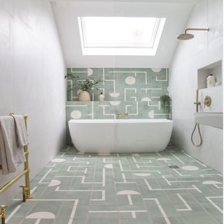 green and white tiles with white bath, gold towel rail, skylight and rainfall shower