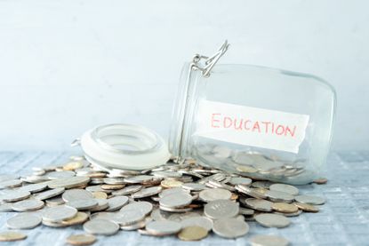 Coins and glass money jar with education label, financial concept.