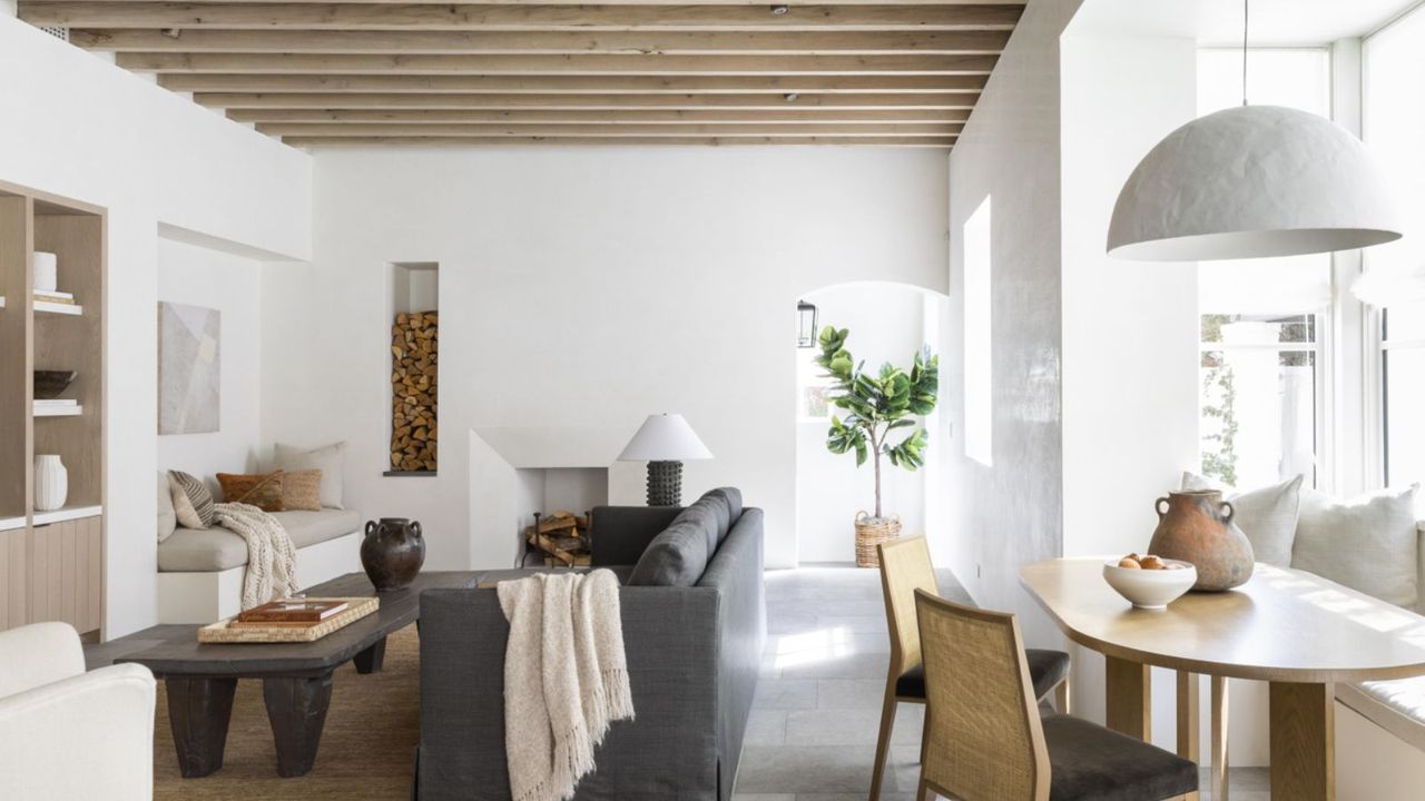 white living room with wood ceiling beams and gray sofa 