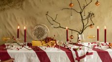 A striking modern table with a red striped tablecloth The Sette inspires us how to decorate a Christmas table