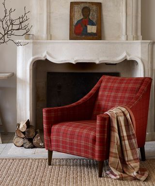Red plaid armchair in front of fireplace