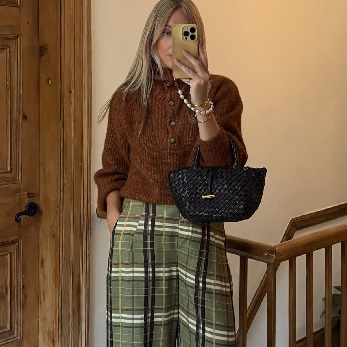 Woman in brown sweater and plaid pants