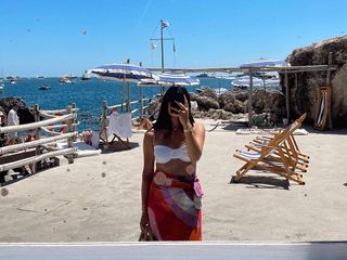 @nicoleakhtarzad in Capri, Italien, trägt weißes Jade-Bade-Bikinioberteil mit buntem Überzug