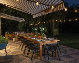 patio with awning, table and lights