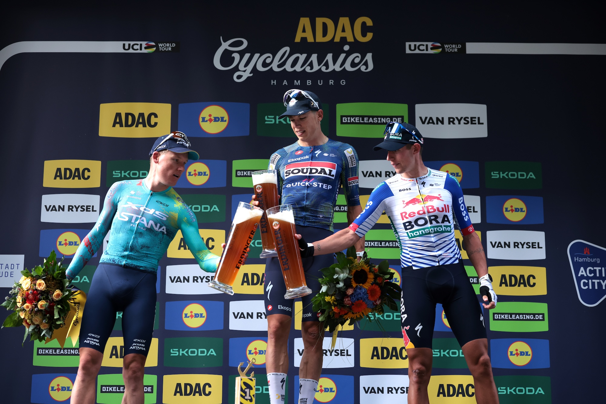 Cheers from the podium (l-r): second place Mike Teunissen (XDS Astana), winner Paul Magnier (Soudal-Quickstep) and third place Laurence Pither (Red Bull-Bora-hansgrohe)