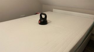 A weight on the REM-Fit 500 Ortho Hybrid mattress