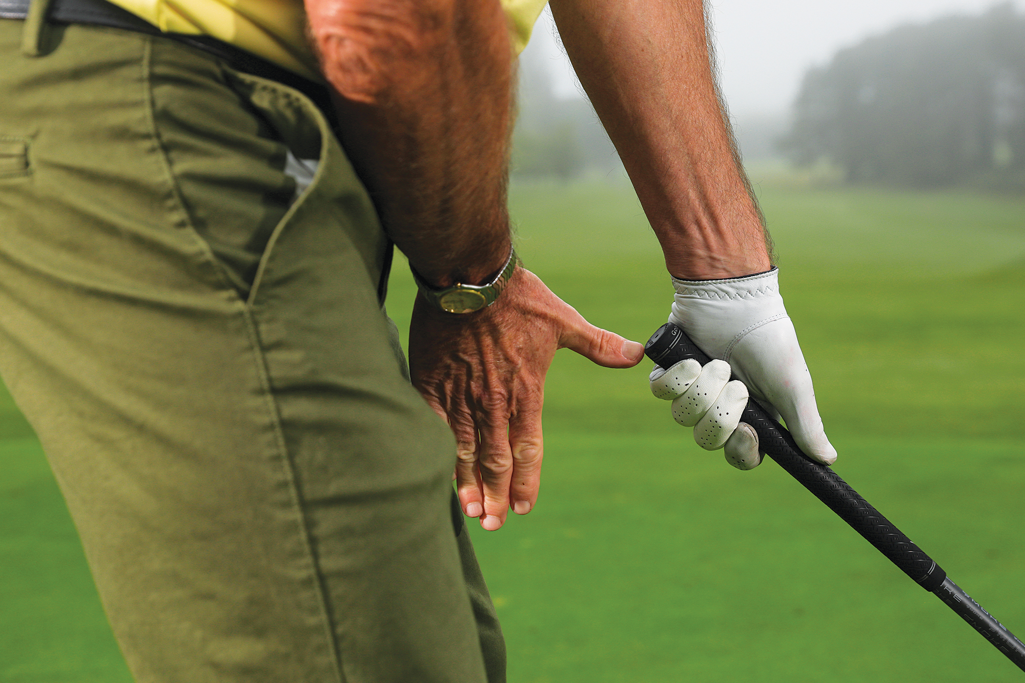 A close up of a drill where the lead hand is on the golf club, but the trail hand is showing the distance between the thighs and the butt of the club