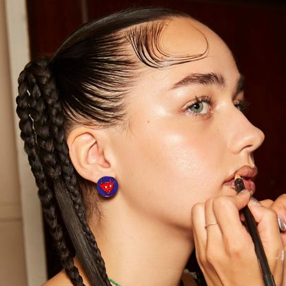 model backstage at Chopova Lowena having lip liner applied