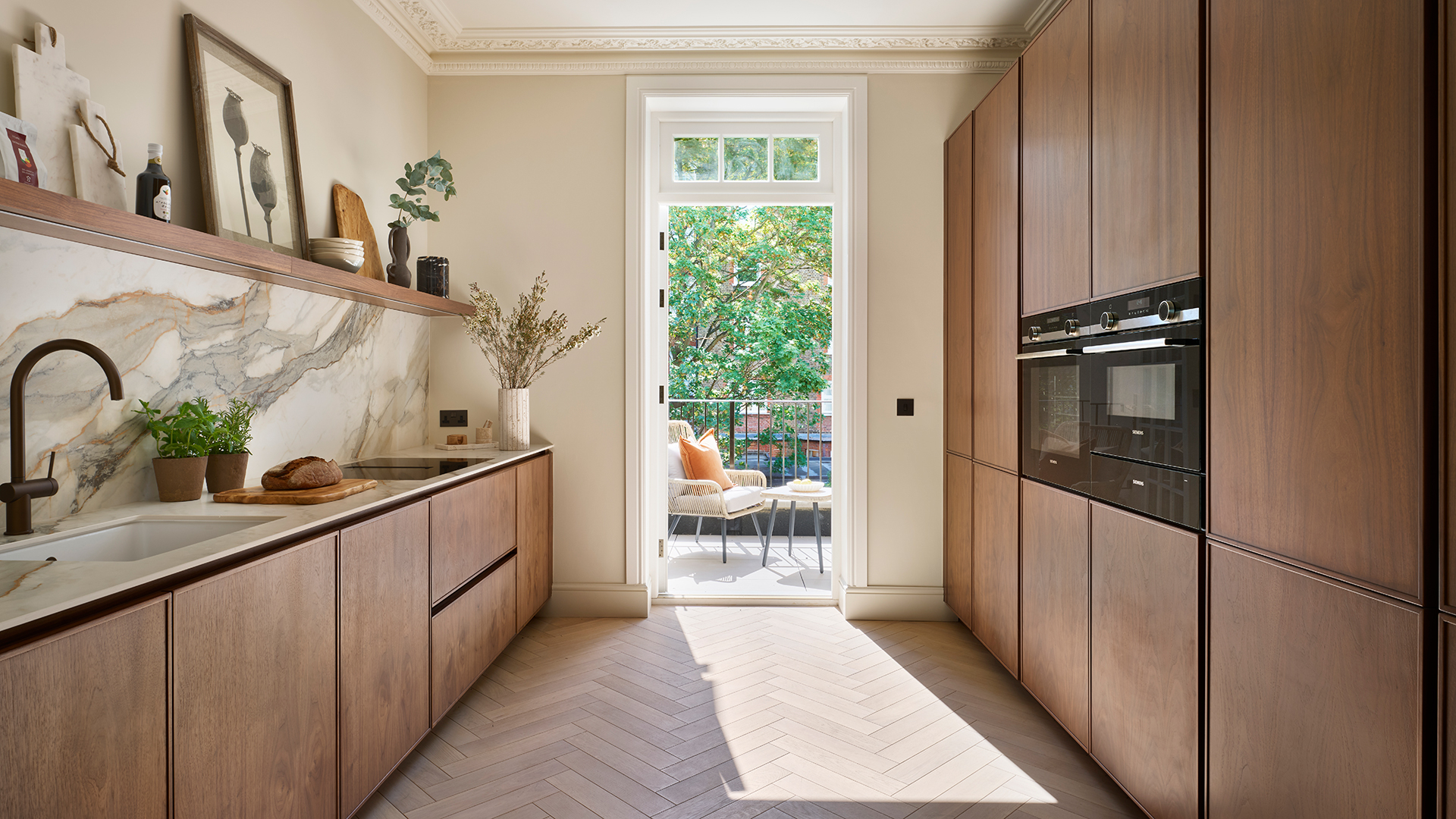 A wooden galley kitchen with a door out to a small balcony
