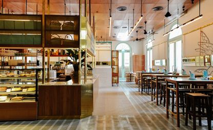 Wooden tables & chairs next to food counter