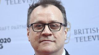 Russell T Davies at BAFTA event wearing glasses and against a white background.