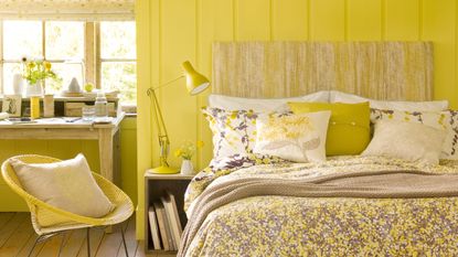 Yellow bedroom with dark wood floors and cream rug
