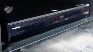 Panasonic DP-UB820 on stand in living room