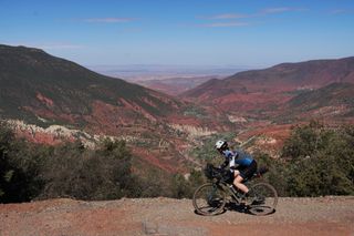 Image shows Anna cycling in the foothills of the Atlas mountains in Morocco
