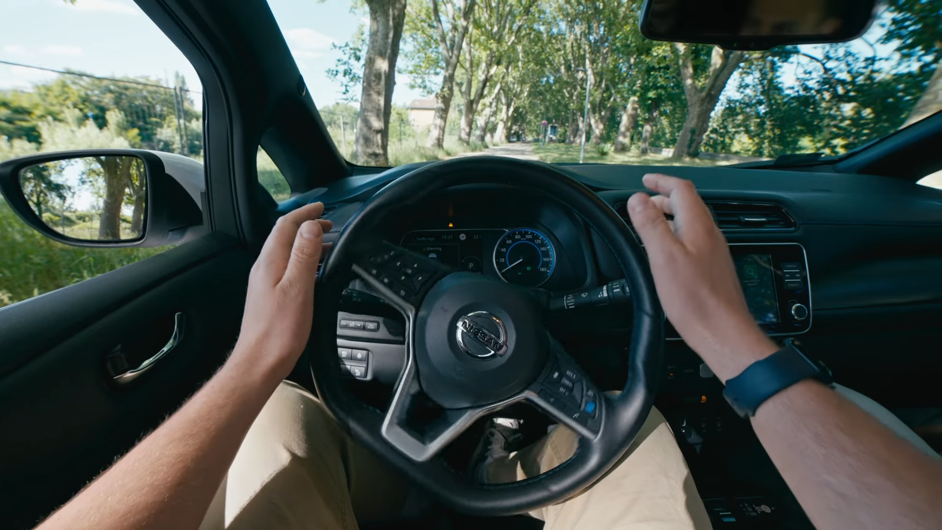A driver seat perspective of a steering wheel turning without the driver's direct control.