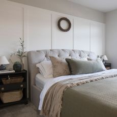 Panelled bedroom with bedside table decorated in neutral colours