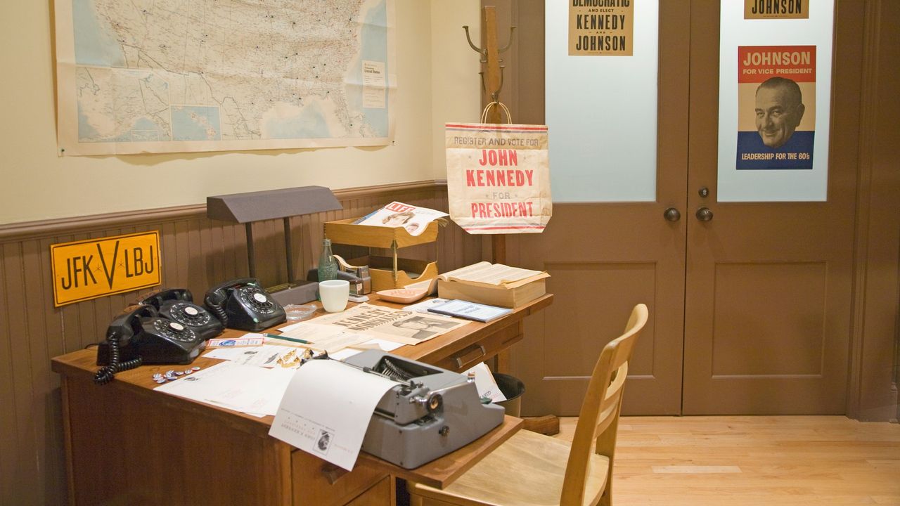 view of a desk at JFK&#039;s presidential library. there are campaign signs visible