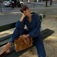 Influencer @juliesfi wears a denim jumpsuit with burgundy slingback heels.