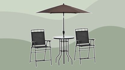 Outdoor garden chairs with umbrella on green background