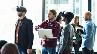 Several colleagues in a meeting with two wearing VR headsets