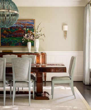 Neutral dining room with half wall panelling and large wooden dining table