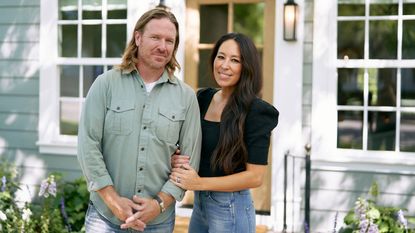 Chip and Joanna Gaines posing in front of Fixer Upper project