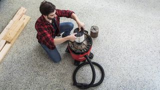 man emptying filter of the Craftsman CMXEVBE17590 shop vacuum