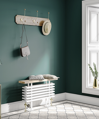 White column radiator with bench seat on top below hooks on the wall