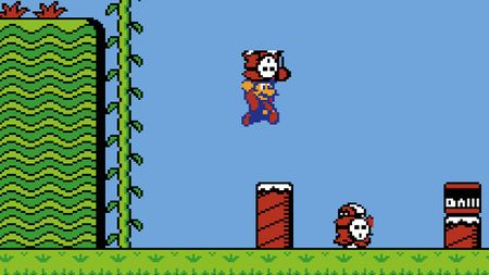 Mario holds a Shy Guy and jumps above grass in Super Mario Bros 2 - from Retro Gamer 252