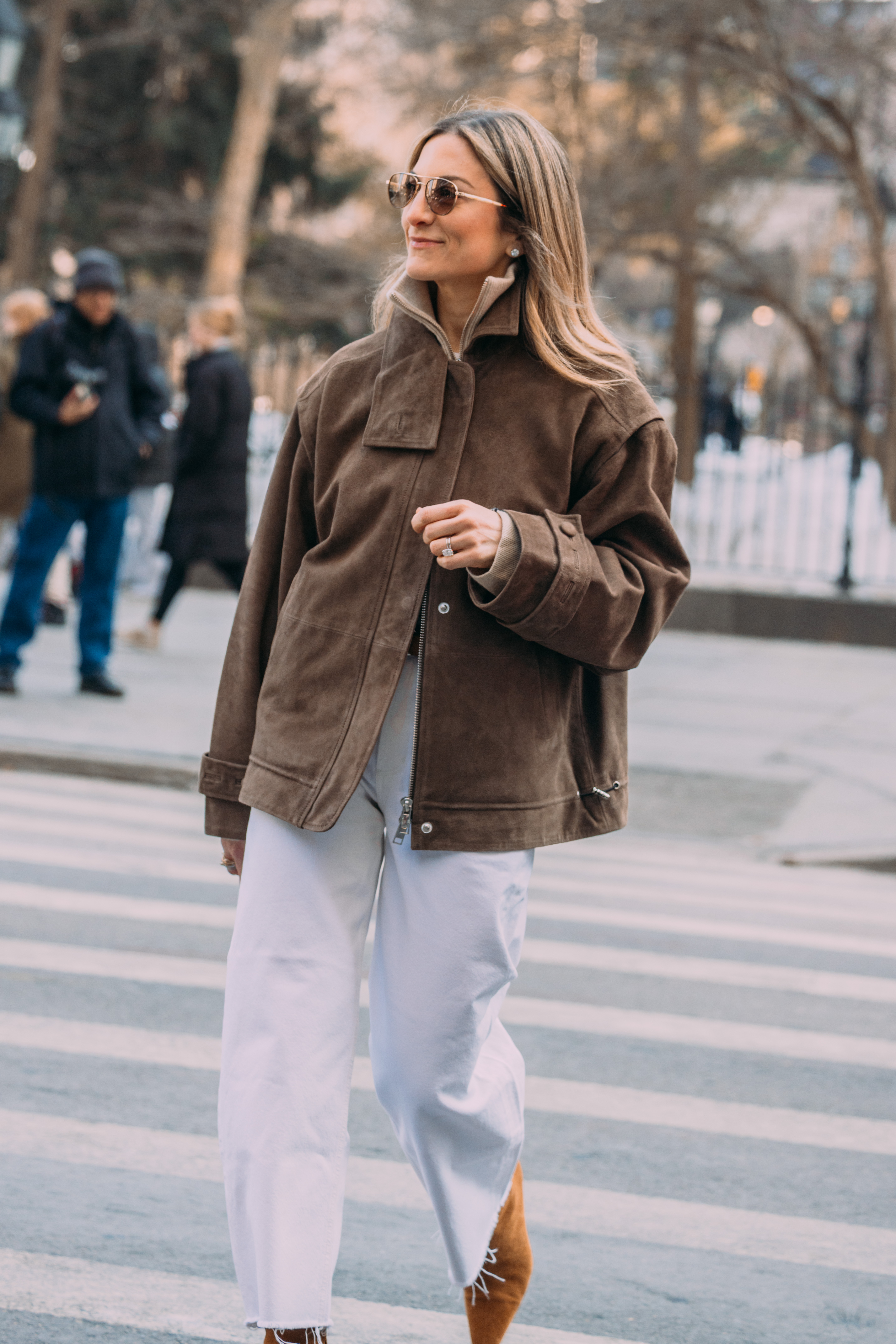 A woman wears frayed jeans with a jacket.