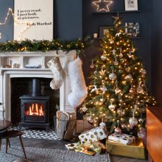 navy blue living room with Christmas tree and fireplace and Christmas stockings hanging on the mantel