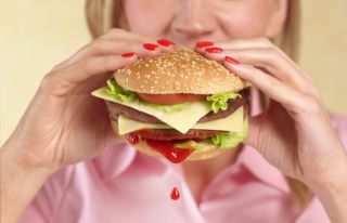 How to remove tricky BBQ stains: women eating burger with ketchup dripping