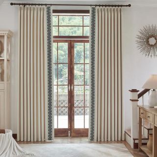 A living room with a floor-to-ceiling wooden door and striped curtains