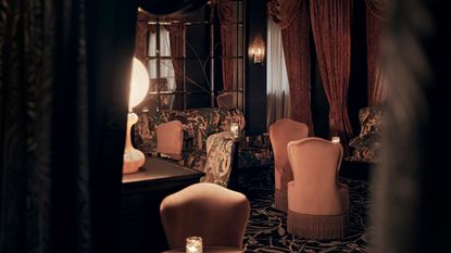 Lounge of one of the best london cocktail bars, part of nomad hotel london, pink chairs and curtains