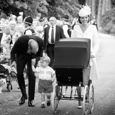 Prince William and Princess Kate walking with Prince George and Princess Charlotte, in a stroller, to her christening