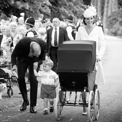 Prince William and Princess Kate walking with Prince George and Princess Charlotte, in a stroller, to her christening