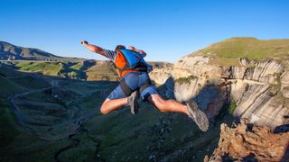 Man BASE jumping off mountain