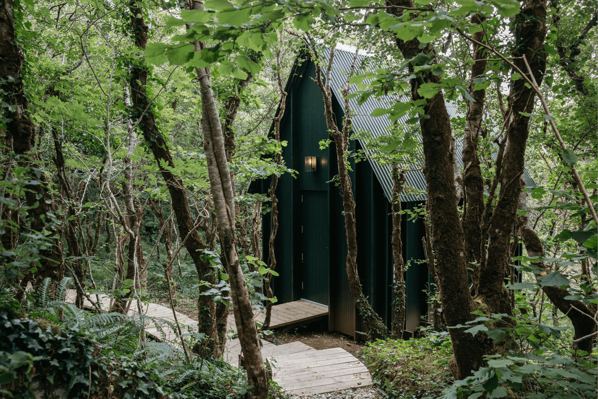 A forest hotel stay boasts minimalist exterior that have it disappear into the surrounding nature, while a seaside one features white-washed walls and terracotta red-painted fixtures.